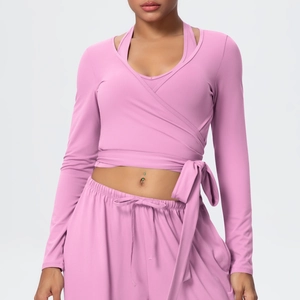 Detail of pink yoga set featuring a V-neck wrap top and high-waist drawstring pants