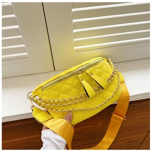 Detail showing bright yellow quilted waist bag with gold chain and double zippers