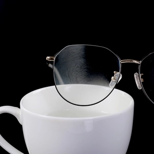 Gold polygon metal frame glasses showing anti-fog lens effect on a white ceramic cup