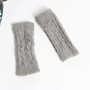 Detail showing the front and inside texture of grey cable knit fingerless gloves