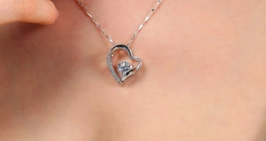 Close-up of heart pendant necklace with shimmering zircon stones worn on the neck