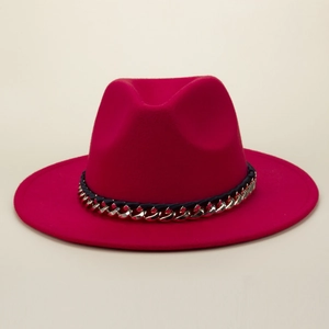Close-up of fuchsia felt fedora hat featuring black ribbon and gold chain detail