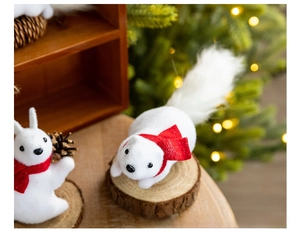 Detail of white plush Christmas squirrel and rabbit ornaments on a rustic wooden base