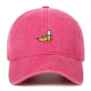 Détail de la broderie banane jaune sur une casquette en coton lavé rose rouge
