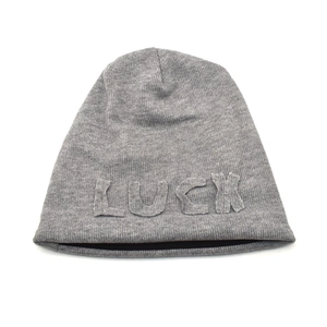 Macro shot of grey knitted beanie fabric with 3D LUCK embroidered patch detail