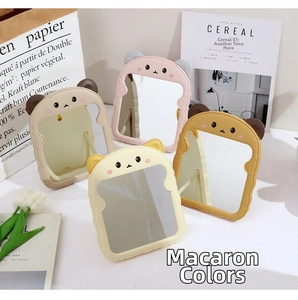 Foldable cartoon animal ears makeup mirrors in macaron colors on a white desktop