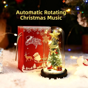 Close-up of rotating Christmas glass dome with LED tree and matching red gift bag