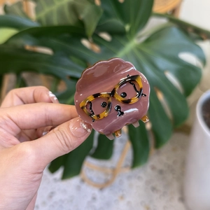 Close-up of a pink acetate hair claw clip featuring a cute dog with glasses design