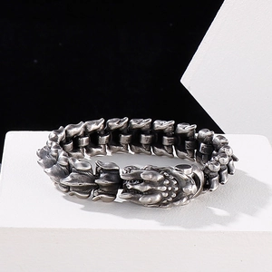 Detalle de pulsera punk de escamas de dragón con acabado antiguo sobre soporte blanco