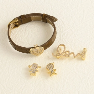 Detail von Lederarmband mit Herz- und Figurenanhängern in 18k Gold-Finish Optik