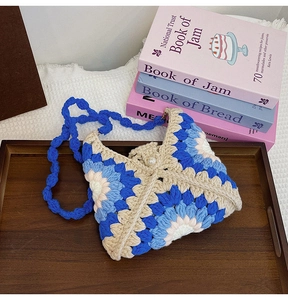 Detail of handmade crochet sunflower bag featuring pearl button and colorful knit textures