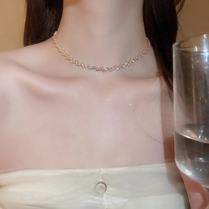 Close-up of elegant gold tassel necklace with zircon stones on female model's neck