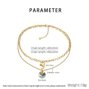 Vue détaillée du collier double couche en acier doré avec pendentifs palmier et dauphin