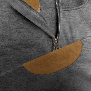 Close-up of zip-up stand collar with brown suede patch on dark gray knitted sweatshirt