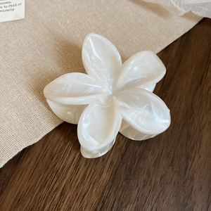 Détail de la pince à cheveux fleur en acrylique avec texture marbrée crème doux