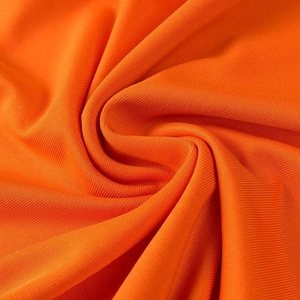 Détail de la texture en maille orange douce et du tissu plissé d'une robe élégante