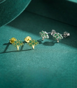 Macro view of 925 sterling silver tree stud earrings with green zircon pavé settings