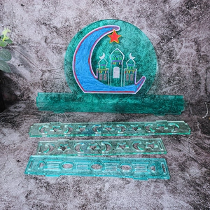 Detail of teal acrylic Eid Mubarak castle storage box mold pieces on grey stone surface