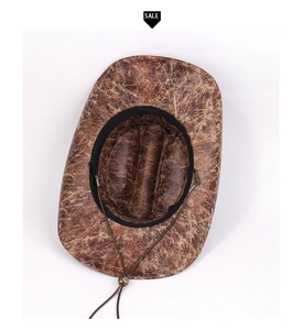 Detailed top view of brown suede cowboy hat featuring vintage cracked texture and chin cord