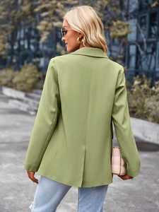 Back view of a green short-sleeved women's blazer with professional patchwork detail