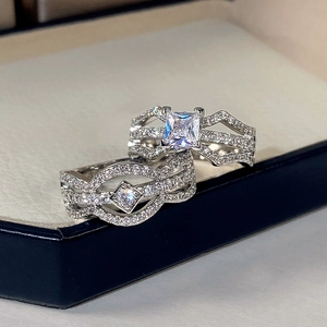 Macro shot of silver wedding ring set featuring square cut zircon and pavé diamond band