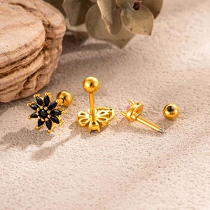 Vintage gold cartilage piercings with black flower gem and pink crystal accents
