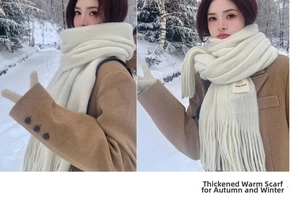 Detail of knit scarf with fringes and handmade label against snowy forest background