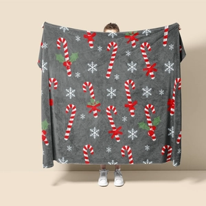 Detail of soft gray Christmas flannel blanket with candy cane and snowflake patterns