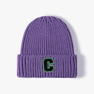 Berretto invernale in maglia spessa viola scuro con toppa lettera C bordo verde