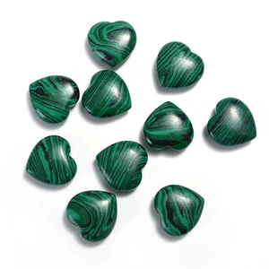 Top view of ten heart-shaped malachite gemstones with natural green stripe patterns