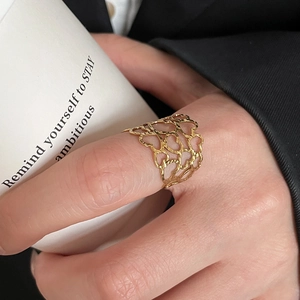Detail showing gold heart cutout ring with refined hammered metal texture on fingers