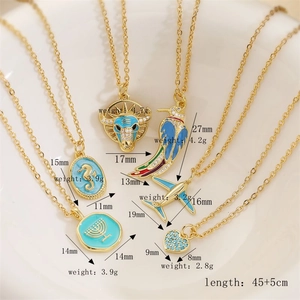 Detail of gold pendants set featuring cow head, bird and heart with size and weight specs