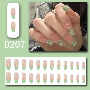 Detail of D207 press-on nails featuring light green French tips and sparkling rhinestones