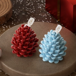 Pinecone-shaped scented candles with Merry Christmas tags on a festive tray