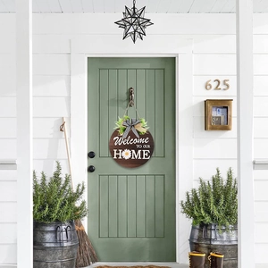 Détail de la plaque de porte Welcome en bois avec nœud à carreaux sur porte verte