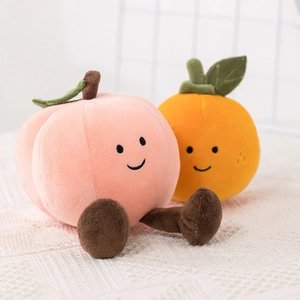 Plush peach and orange fruit dolls with cute faces on white lace background