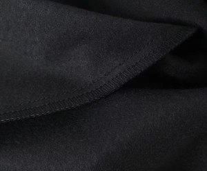 Detalle de cerca de la textura de tela de lana negra y acabados de costura de alta calidad