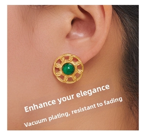 Close-up of vintage gold-plated round earring with green natural stone on model's ear