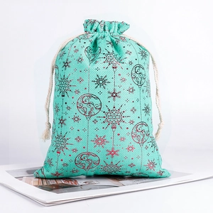 Detail of mint green linen drawstring bag with red snowflake patterns for Christmas gifts
