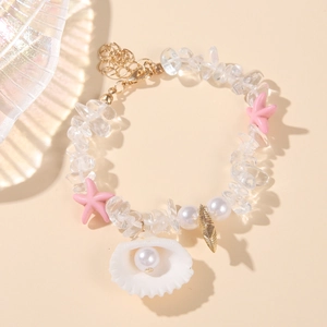 Close-up of summer beach bracelet with seashell charms, starfishes and white pearls