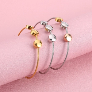Three minimalist stainless steel twisted wire bracelets in gold, silver, and rose gold finishes