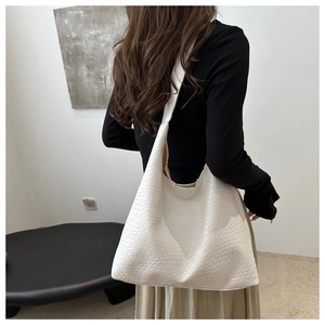 Close-up of white woven texture large tote bag shown on model for daily commuting