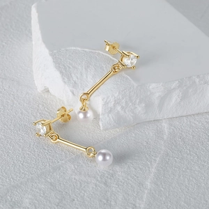 Detail of 925 sterling silver gold earrings with round crystals and white pearls