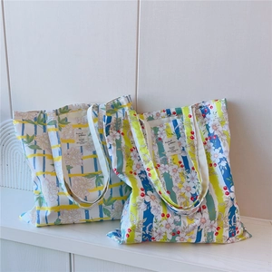 Gros plan sur un sac cabas en toile de coton avec imprimé floral et rayures colorées