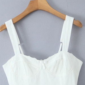 Top caraco blanc ajusté en dentelle avec nœud et bretelles réglables sur cintre en bois