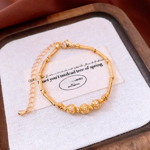 Macro shot of 18K gold plated bamboo-style bracelet with sparkling crystal beads and texture