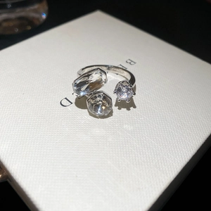 Macro detail of silver geometric open ring featuring clear cubic zirconia in claw settings