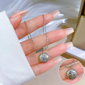 Détail du collier en acier titane avec pendentif caractère Fu et nacre incrustée