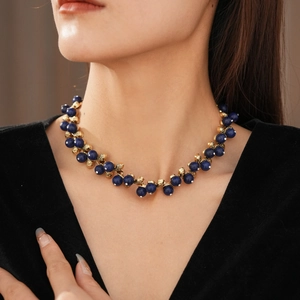 Close-up of vintage style necklace with deep blue beads and gold metallic accents