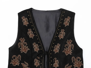 Détail du gilet en daim noir avec broderie florale marron et fermeture à nouer en V